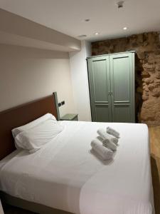 a bedroom with a bed with towels on it at Boutique Hotel Castilla in Soria