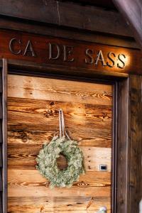 a wreath on a wooden wall with a sign at Ca' De Sass in Pila