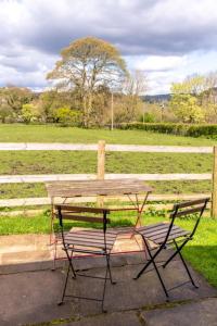 a wooden table and chair in front of a fence at The Carriage in Matlock