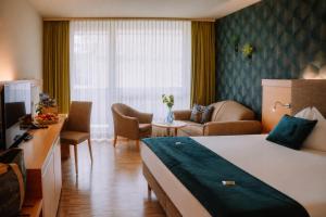 a hotel room with a bed and a living room at Hotel Auszeit St Lambrecht in Sankt Lambrecht