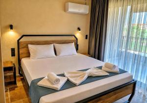 a bedroom with a bed with two towels on it at RCR The Stones in Flogita +19 photos