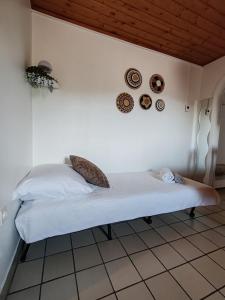 a bed in a room with plates on the wall at Terme Olimia - Apartment Lipa 112 in Podčetrtek +21 photos
