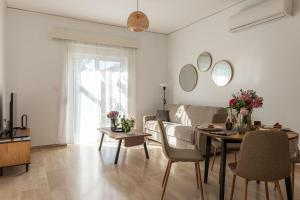 a living room with a couch and a table at Filerimos Nest - Private Countyard in Pastida