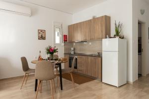 a kitchen with a table and a white refrigerator at Filerimos Nest - Private Countyard in Pastida