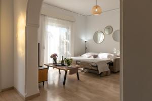 a bedroom with a bed and a table and a window at Filerimos Nest - Private Countyard in Pastida