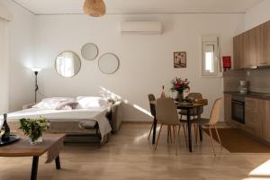 a bedroom with a bed and a table and chairs at Filerimos Nest - Private Countyard in Pastida +15 photos