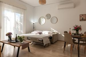 a bedroom with a bed and a table and chairs at Filerimos Nest - Private Countyard in Pastida