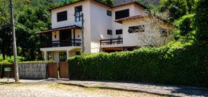 a house with a hedge in front of it at Casa aconchegante in Teresópolis
