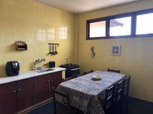 a kitchen with a table with chairs and a sink at Casa aconchegante in Teresópolis +4 photos