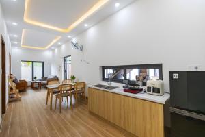 a kitchen and living room with a table and chairs at Happy House Villa Phu Quoc in Phú Quốc