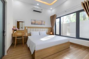 a bedroom with a large white bed and a window at Happy House Villa Phu Quoc in Phú Quốc