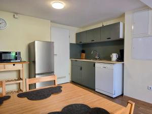 a kitchen with a stainless steel refrigerator and white cabinets at Kamus in Baden-Baden