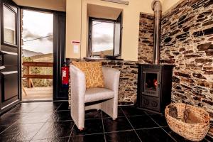 a living room with a chair and a fireplace at Férias na Serra # Natureza # Casa da Professora By ALzira in Seia +48 photos