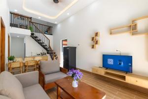 a living room with a couch and a tv at Happy House Villa Phu Quoc in Phú Quốc