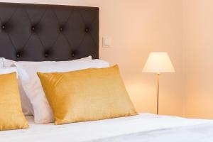 a bedroom with a bed with a black headboard and a lamp at Vandalou By ALzira in Albufeira