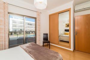 a bedroom with a bed and a large window at Vandalou By ALzira in Albufeira +26 photos