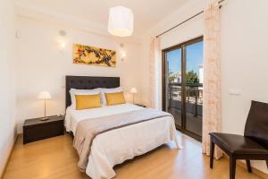 a bedroom with a bed and a large window at Vandalou By ALzira in Albufeira
