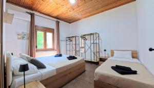 a bedroom with two beds and a window at Villa del Vino in Mikrós Prínos