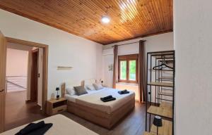 a bedroom with a bed and a wooden ceiling at Villa del Vino in Mikrós Prínos