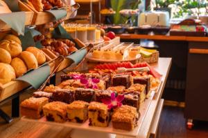 a buffet filled with different types of cakes and pastries at Fama Residence Gdańsk Old Town in Gdańsk