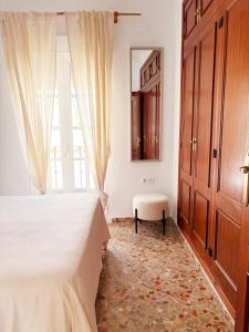 a bedroom with a bed and a window and a chair at La Duquesita - Ideal para escapada en pareja in Arcos de la Frontera