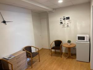 a room with a table and two chairs and a microwave at Jazz Time Studio in Birštonas
