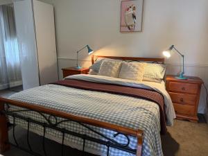 a bedroom with a bed with two lamps on it at Fitzroy Cottage one bedroom CBD accommodation in Tamworth