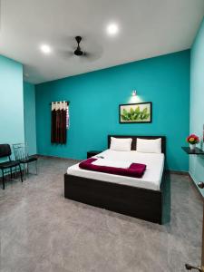 ein Schlafzimmer mit einem Bett und einer blauen Wand in der Unterkunft Prasant Inn in Bhubaneshwar