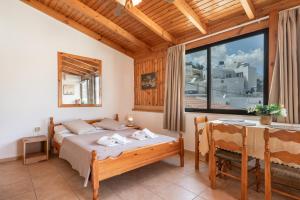 a bedroom with a bed and a table and a window at Nikos House in Ierapetra