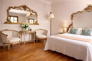 a bedroom with a bed and a mirror and chairs at Antico Casale Formica in Bagheria