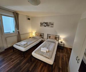 two beds in a room with wooden floors at Apartment "North Star" in Dinkelsbühl