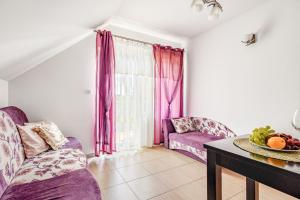 a living room with a purple couch and a table at Pokoje JANTARUS in Jantar
