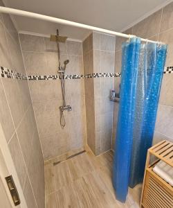 a shower with a blue shower curtain in a bathroom at Apartment "North Star" in Dinkelsbühl +17 photos