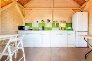 a kitchen with white appliances and a wooden ceiling at Pokoje JANTARUS in Jantar