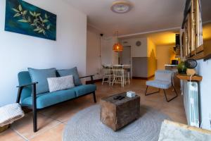 a living room with a blue couch and a table at Casa Sabor de la Vida in Abarán