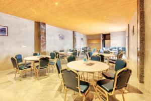 a restaurant with tables and chairs in a room at Kason Grand View Manali in Manāli