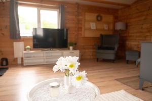 a living room with a table with flowers on it at Ferienhaus Wasserläufer Bellin in Ueckermünde