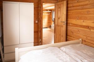a bedroom with a bed and a wooden wall at Ferienhaus Wasserläufer Bellin in Ueckermünde