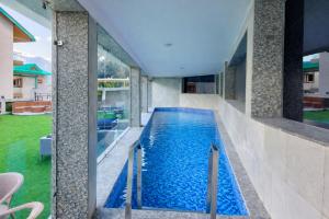 a swimming pool in the middle of a house at Kason Grand View Manali in Manāli