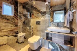 a bathroom with a toilet and a sink at Kason Grand View Manali in Manāli +39 photos