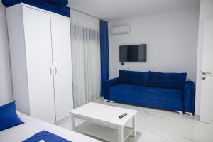a living room with a blue couch and a table at Nejla Apartmani Stoj in Ulcinj