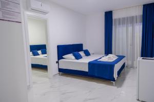 a bedroom with a blue and white bed and a mirror at Nejla Apartmani Stoj in Ulcinj
