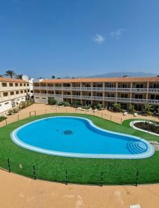 a large swimming pool in front of a building at Apartamento ELIDE in Costa Del Silencio