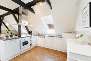 a kitchen with white cabinets and a wooden floor at Vadersdorf 31 Im Backhaus in Vadersdorf