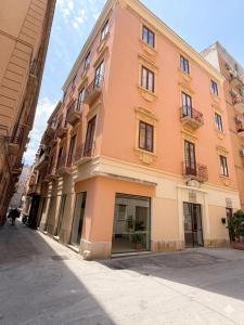 a pink building on a street in a city at La Mattanza in Trapani