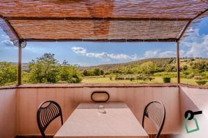 a table and chairs on a porch with a view at Hotiday Massa Marittima in Massa Marittima