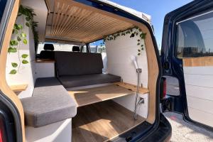 an open door of an rv with a bench inside at La Vallena Camper in Madrid