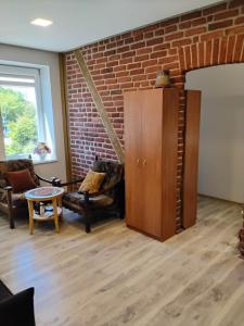 a living room with furniture and a brick wall at Apartamentai Heydekrug in Šilutė
