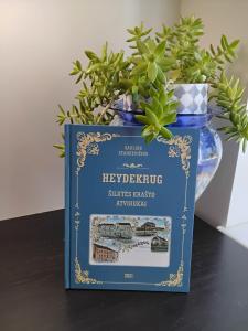 a book sitting on a table next to a vase at Apartamentai Heydekrug in Šilutė +6 photos