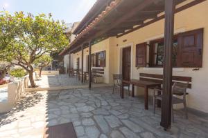 a patio with tables and chairs on a building at Alkyoni Forest Rooms in Skala